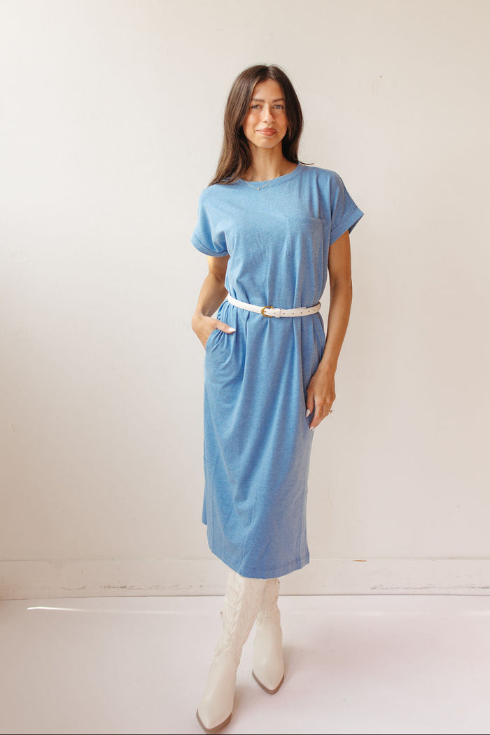 Woman wearing a light blue dress with a belt on a white background