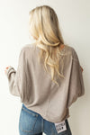 mode, with open arms sweater
